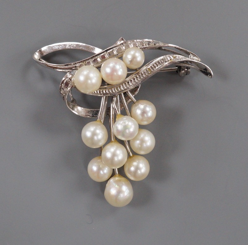 A modern 14k and graduated eleven stone cultured pearl cluster set brooch, 40mm, gross weight 7.4 grams.